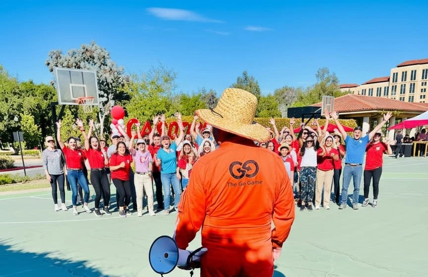 Host with a megaphone facing a cheering group