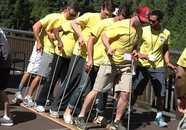 Team in yellow shirts racing a skateboard plunger relay